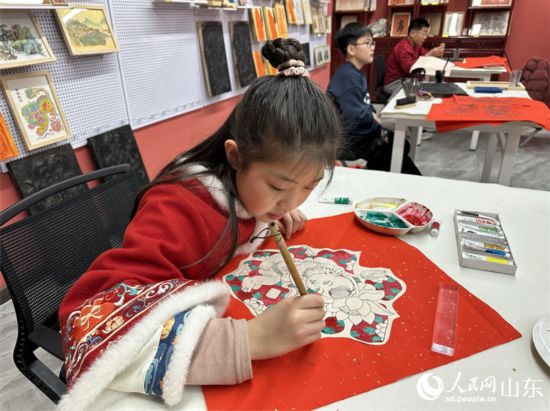小學(xué)生在社教研學(xué)項目中給年畫填色。 人民網(wǎng) 喬姝攝